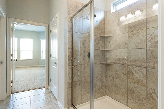 bathroom with a shower with door, plenty of natural light, and tile patterned floors