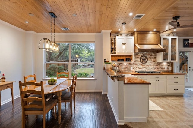 kitchen with premium range hood, sink, pendant lighting, and white cabinets