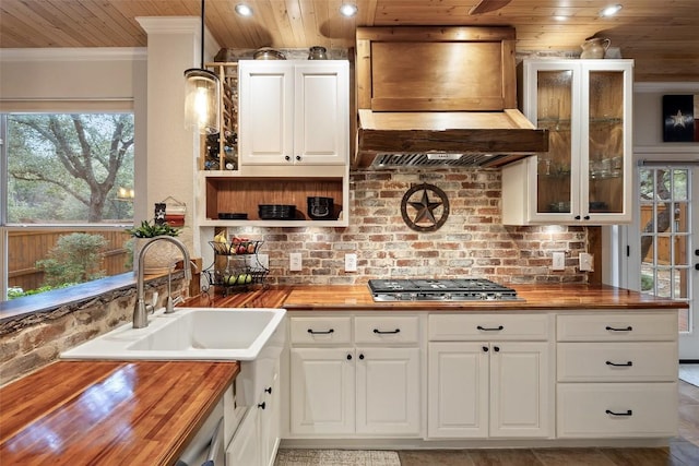 kitchen with premium range hood, stainless steel gas stovetop, and butcher block counters