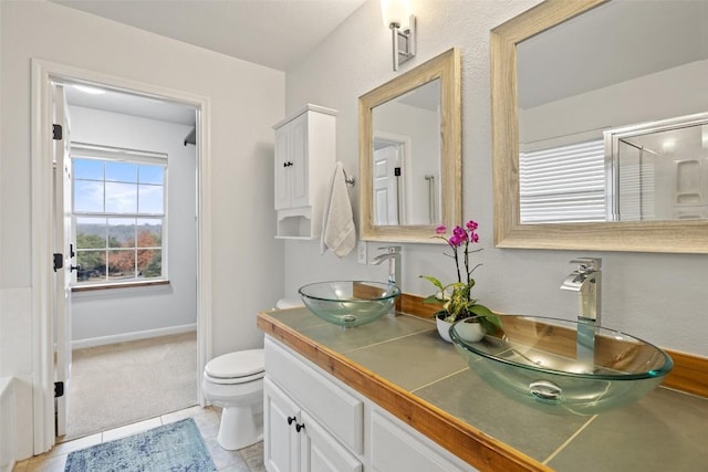 bathroom with tile patterned flooring, vanity, and toilet