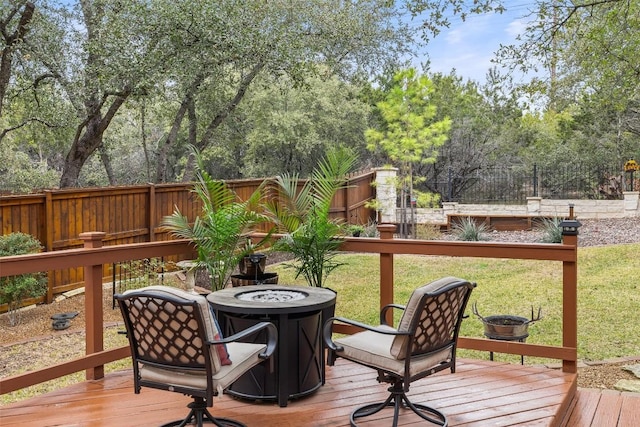 wooden deck featuring a yard and an outdoor fire pit