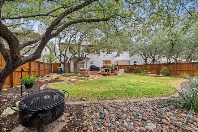 view of yard with a deck and an outdoor fire pit