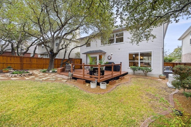 rear view of property with a wooden deck and a yard