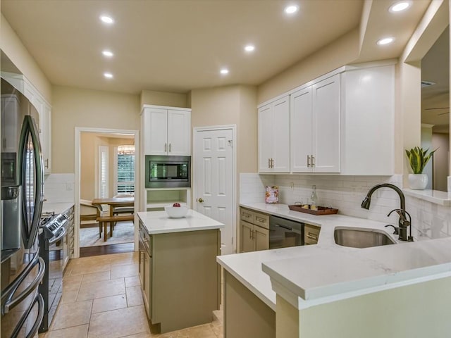 kitchen featuring sink, a center island, range with gas stovetop, built in microwave, and kitchen peninsula