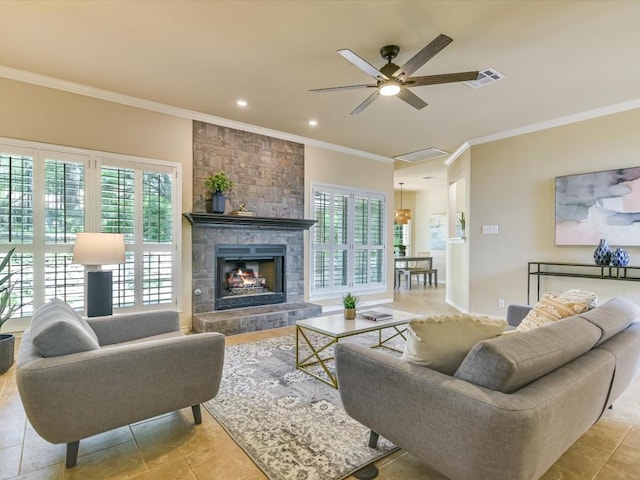 living room with ornamental molding, a stone fireplace, a healthy amount of sunlight, and ceiling fan