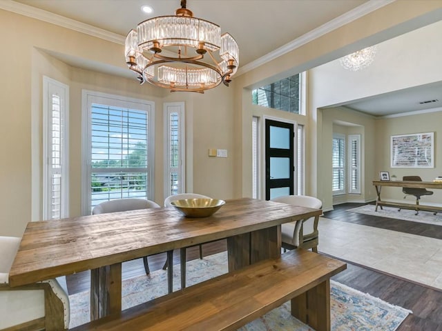 dining room with an inviting chandelier, plenty of natural light, crown molding, and wood-type flooring