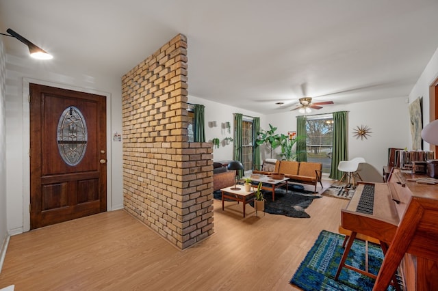 foyer entrance featuring ceiling fan and light wood-type flooring