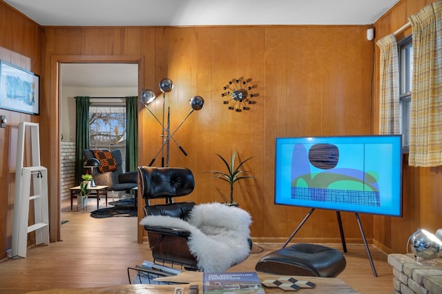 sitting room with wooden walls and light hardwood / wood-style flooring