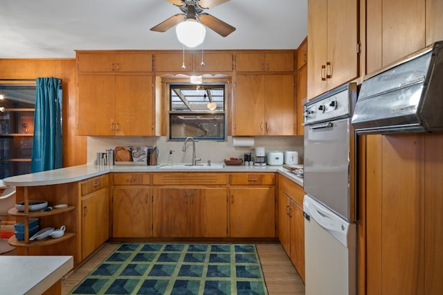 kitchen with ceiling fan, sink, oven, and white dishwasher