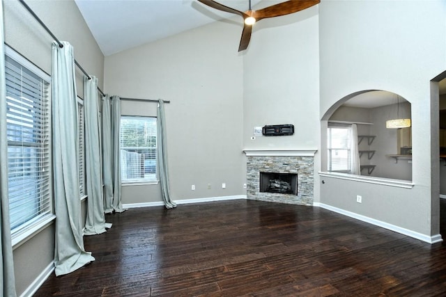 unfurnished living room featuring hardwood / wood-style floors, a stone fireplace, and a healthy amount of sunlight