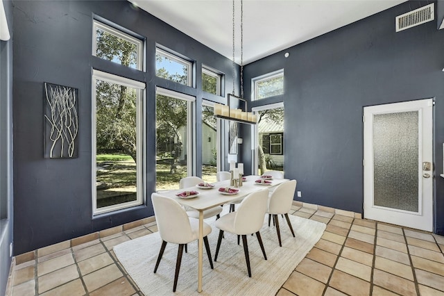 dining space featuring light tile patterned floors and a high ceiling