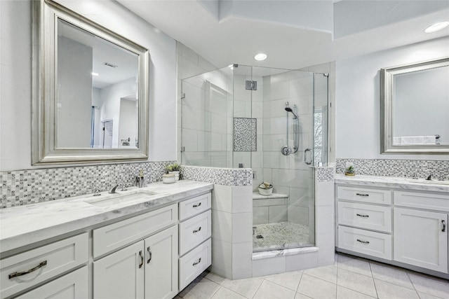 bathroom featuring vanity, tile patterned floors, backsplash, and a shower with shower door