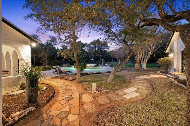 yard at dusk featuring a patio