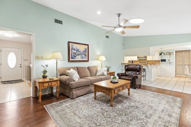 living room with vaulted ceiling, hardwood / wood-style floors, and ceiling fan