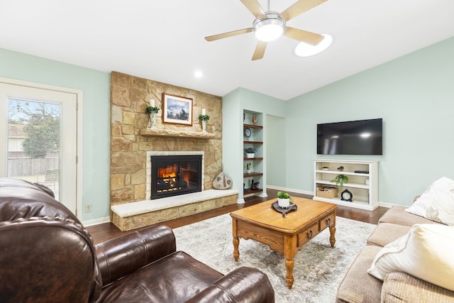 living room with lofted ceiling, hardwood / wood-style flooring, a fireplace, and built in shelves