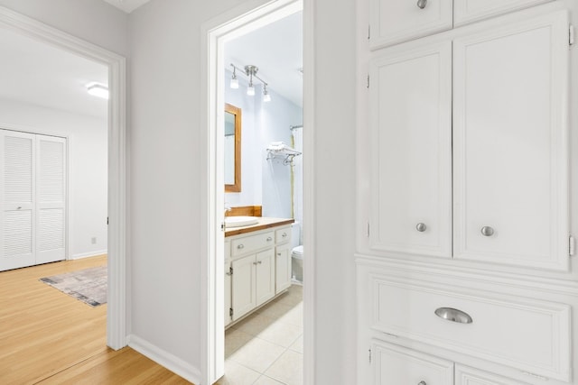 hallway featuring sink and light hardwood / wood-style flooring