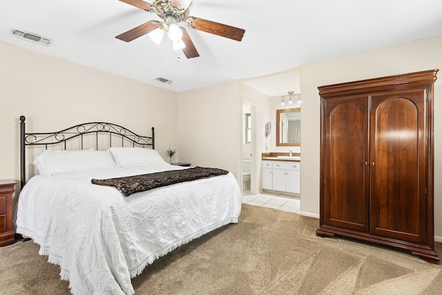 carpeted bedroom with ceiling fan, connected bathroom, and sink