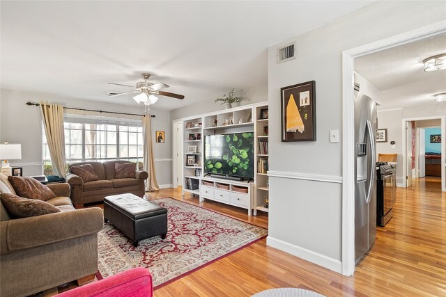 living room with wood-type flooring and ceiling fan