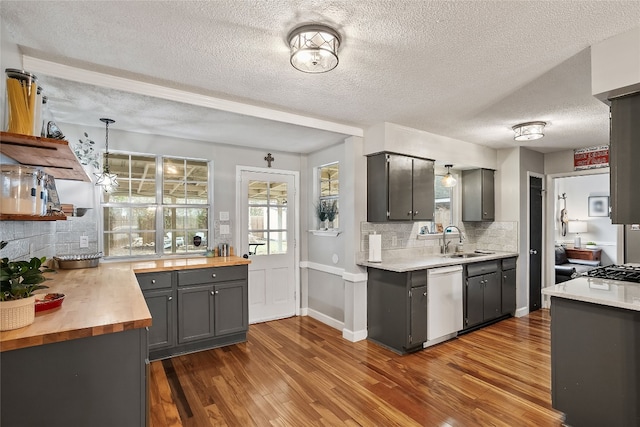 2502 Spruceleaf Cir, Austin, TX 78757 - kitchen with white dishwasher, a sink, butcher block countertops, backsplash, and dark wood-style flooring