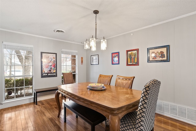 dining area featuring crown molding, dark hardwood / wood-style floors, a notable chandelier, and a textured ceiling