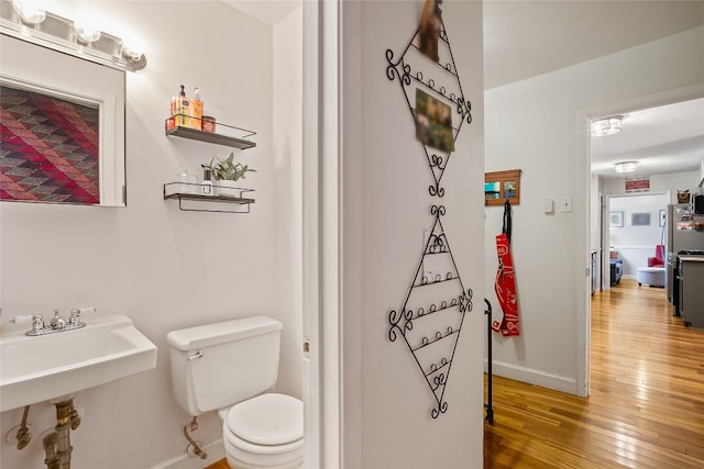 bathroom featuring wood-type flooring and toilet