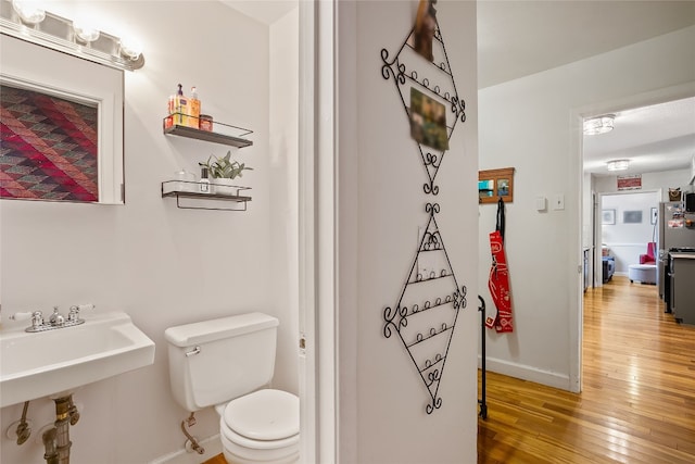 2502 Spruceleaf Cir, Austin, TX 78757 - half bath featuring hardwood / wood-style flooring, baseboards, toilet, and a sink