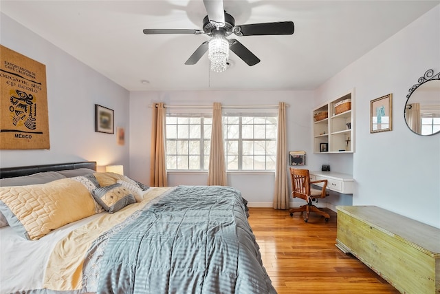 bedroom with light hardwood / wood-style flooring, built in desk, and ceiling fan