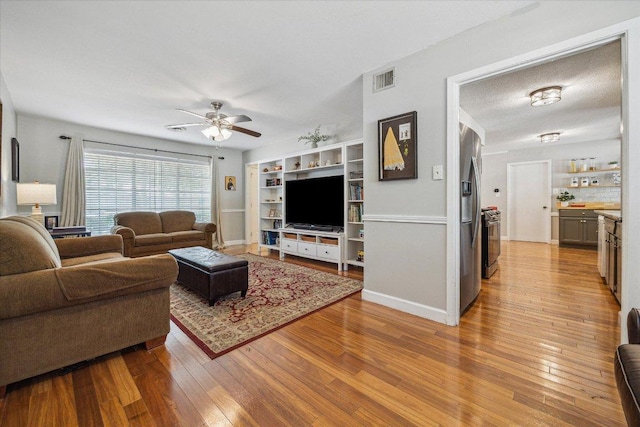 2502 Spruceleaf Cir, Austin, TX 78757 - living area featuring light wood-style flooring, ceiling fan, and baseboards
