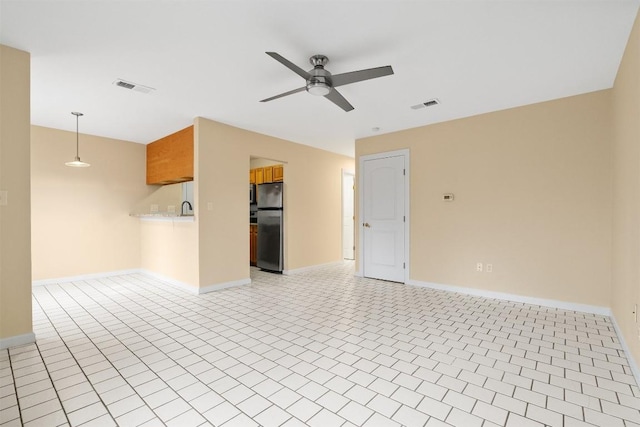 spare room with ceiling fan and light tile patterned flooring