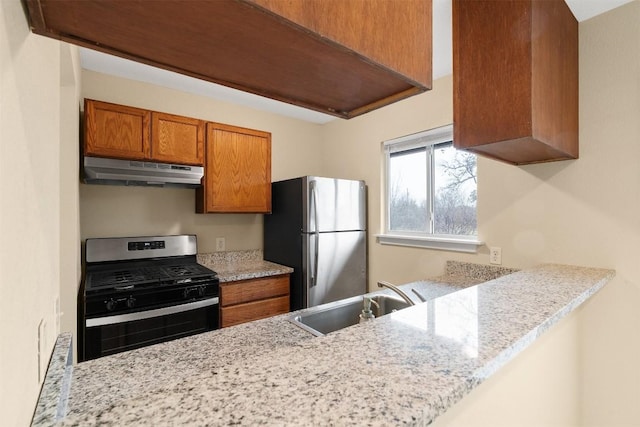 kitchen with appliances with stainless steel finishes, light stone countertops, sink, and kitchen peninsula