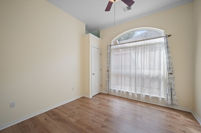 unfurnished room with ceiling fan, crown molding, and light wood-type flooring