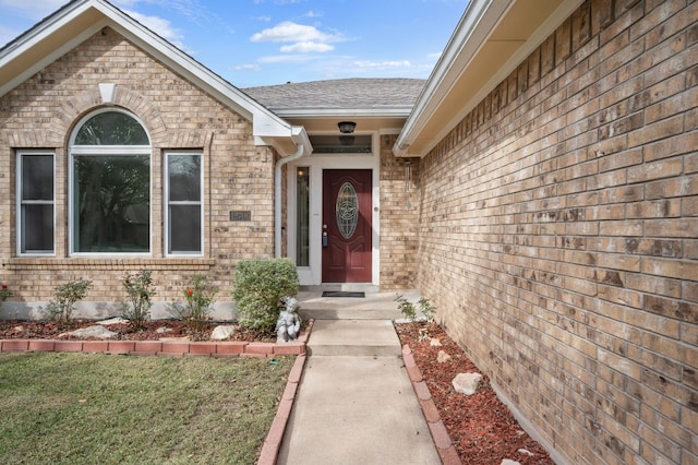 view of exterior entry with a lawn