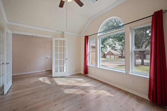 empty room with french doors, lofted ceiling, crown molding, ceiling fan, and light hardwood / wood-style floors