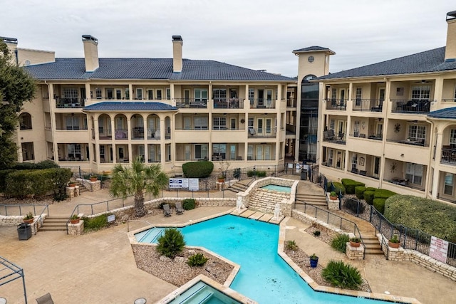 community pool featuring fence and a community hot tub