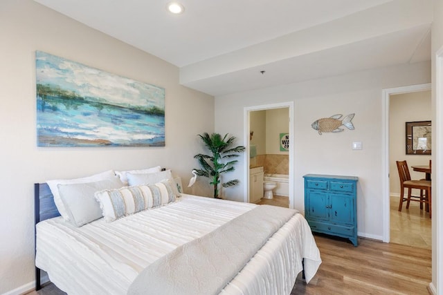 bedroom with ensuite bathroom, recessed lighting, baseboards, and light wood-style floors
