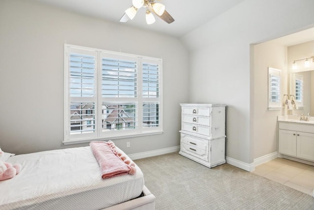 bedroom featuring ceiling fan, light colored carpet, ensuite bathroom, and sink