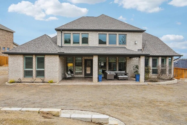 back of property with an outdoor living space and a patio area