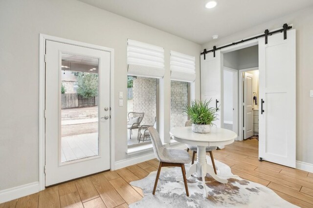 dining space featuring hardwood / wood-style flooring and a barn door