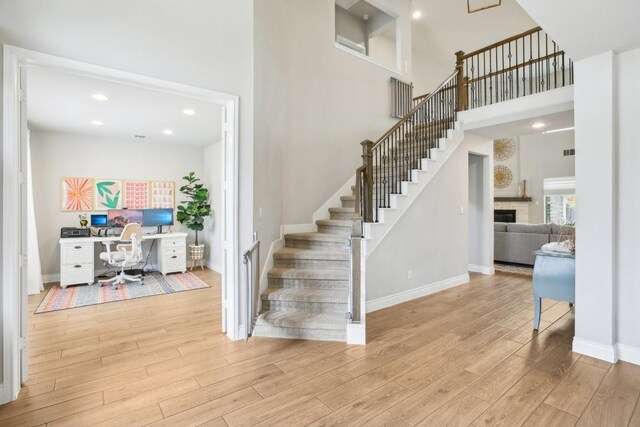 stairway featuring hardwood / wood-style flooring and a towering ceiling