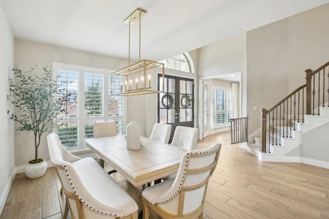 dining area featuring light hardwood / wood-style flooring, french doors, a chandelier, and plenty of natural light