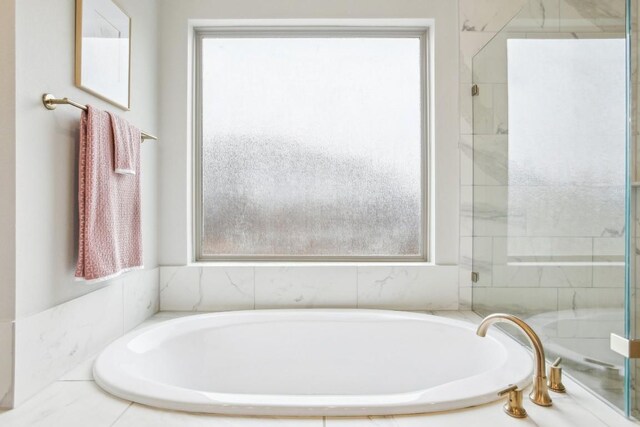 bathroom featuring tiled tub