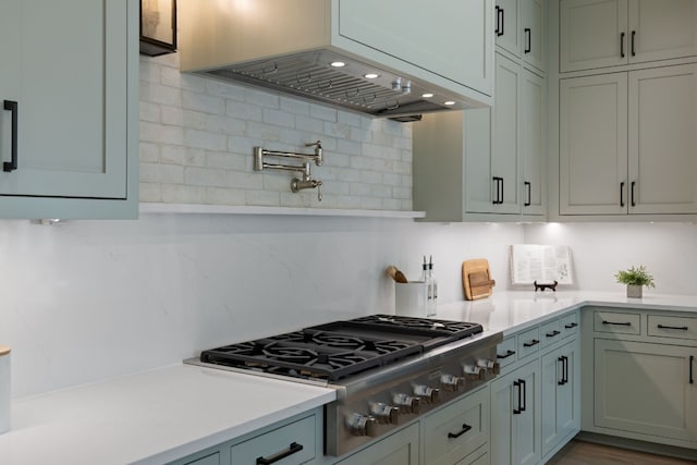 kitchen featuring premium range hood, stainless steel gas cooktop, and backsplash