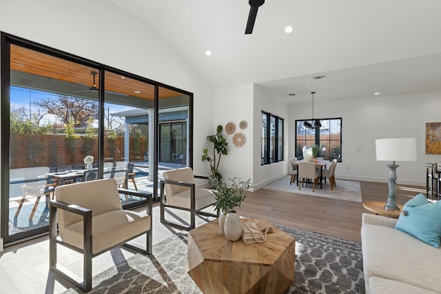 living room featuring lofted ceiling, ceiling fan, and light wood-type flooring