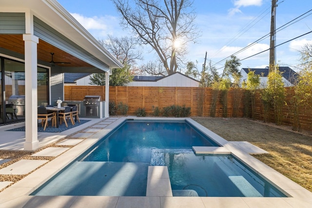 view of swimming pool with grilling area, ceiling fan, and a patio area