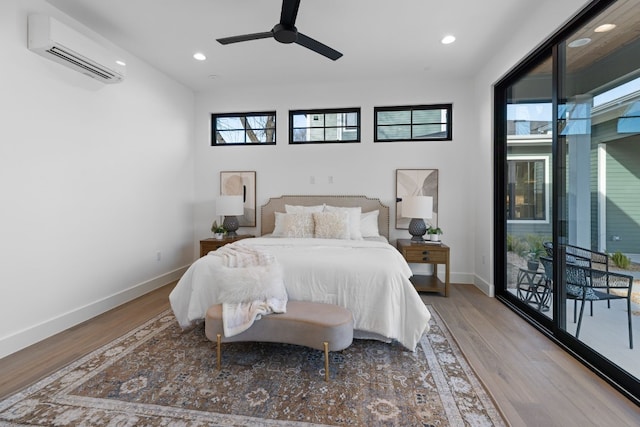 bedroom featuring ceiling fan, a wall mounted air conditioner, and hardwood / wood-style floors