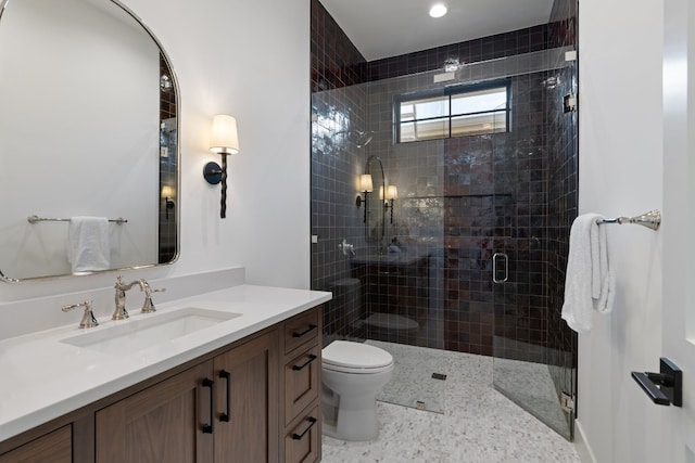 bathroom featuring vanity, toilet, and an enclosed shower