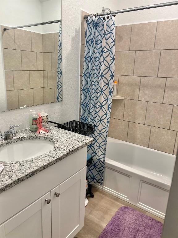 bathroom with vanity, hardwood / wood-style floors, and shower / bath combination with curtain