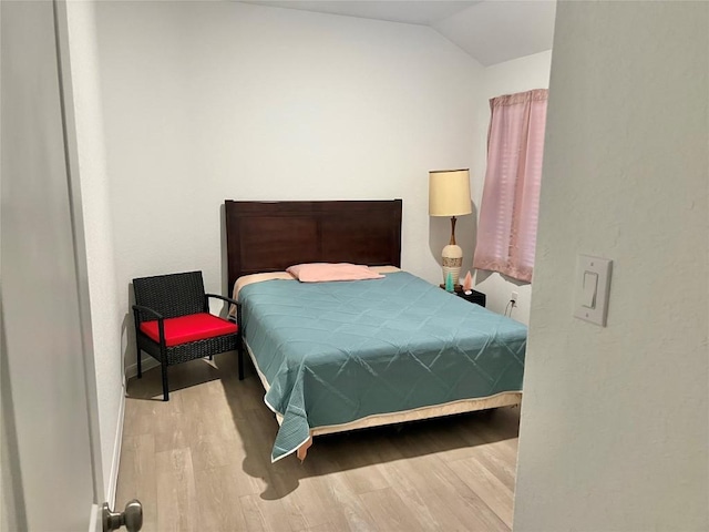 bedroom with lofted ceiling and light hardwood / wood-style flooring