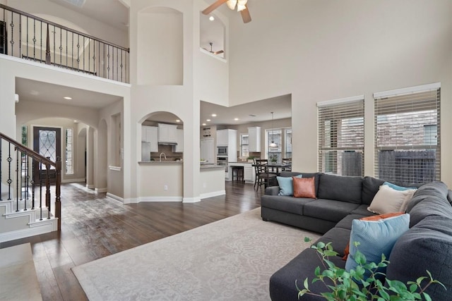 living room with dark hardwood / wood-style flooring, sink, and ceiling fan