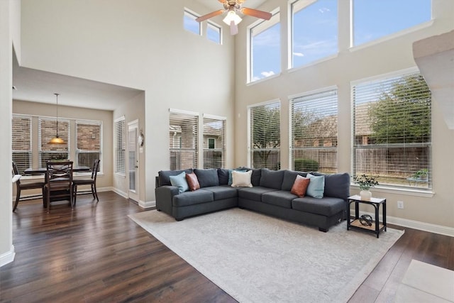 living room featuring ceiling fan and dark hardwood / wood-style flooring